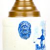 Een Delfts porseleinen tabakspot blauw-wit met opschrift en rokende Indiaan in het decor. Leeuwenhoofden aan de zijkant en onderaan gemerkt “De Porceleyne Clauw”.