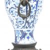 Een Chinees blauw-wit porseleinen vaas met koperen handvatten en voetje.