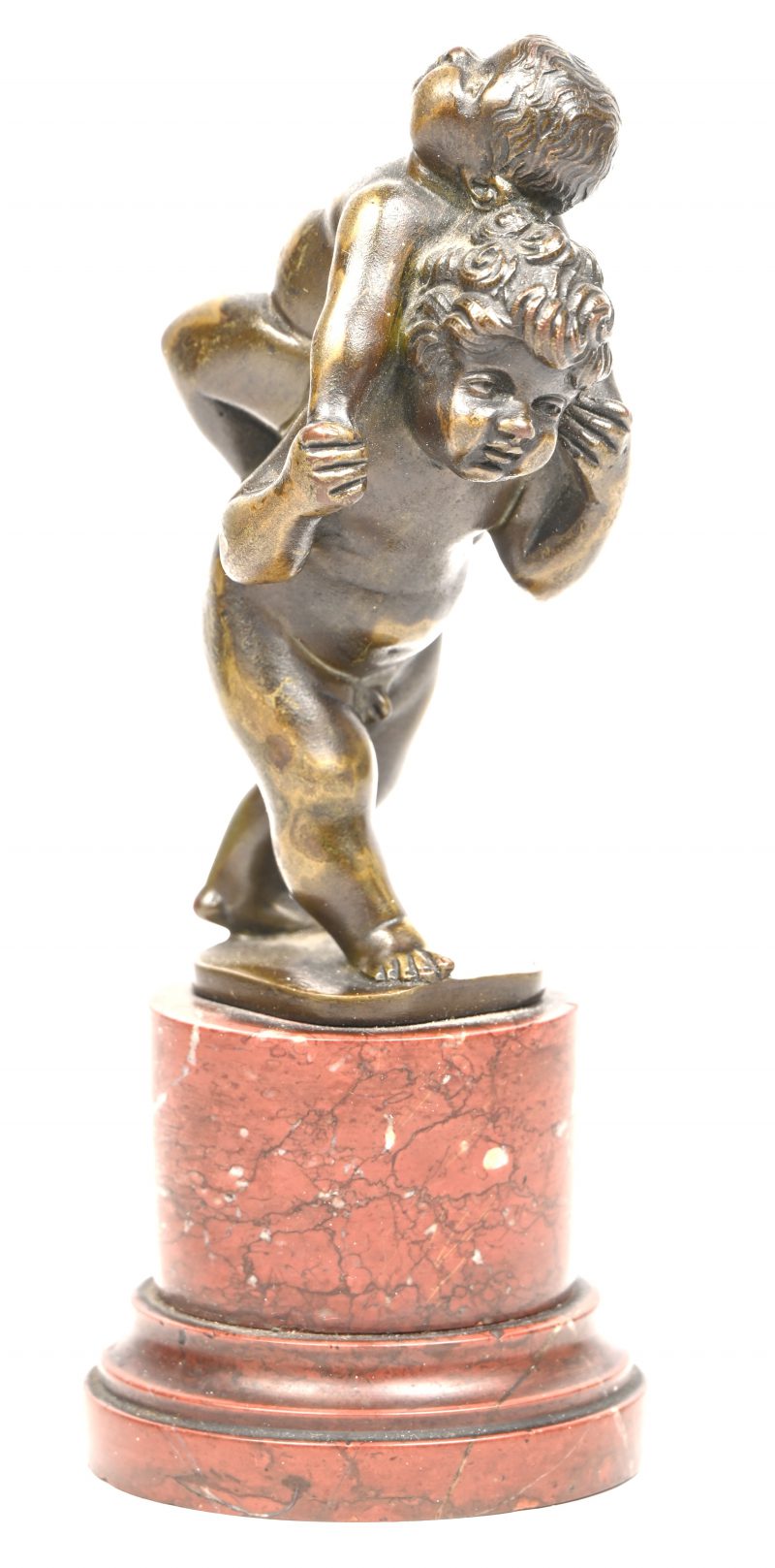 Een bronzen beeldje met twee Putti op een rood marmeren sokkeltje.
