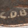 “Verlegen naakt”. Een bronzen beeld, onderaan monogram CDB. En “naakt”, een houten gesculpteerd beeldje, onderaan gesigneerd.