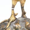 Een bronzen beeldje van een haan, gesigneerd T. Hinod? Eén pootje is gebroken.