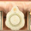 Een 19e eeuws juwelenkistje met bijhorende parfumflesjes met vergulde dopjes in de vorm van een ladekastje in oa. notenfineer. Er ontbreekt één trekkertje aan het verborgen laatje. Het plaatje voor het sleutelgat is nog aanwezig.