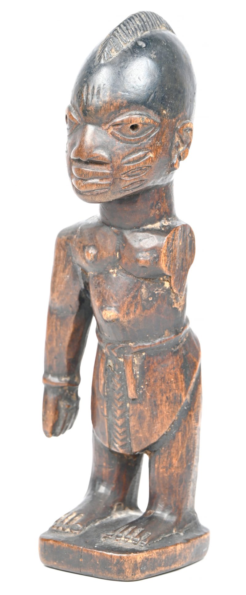 “Ibedji”. Een houten gesculpteerd vruchtbaarheidsbeeldje van de Yoruba, een figuur met afgesneden armen, waarvan 1 terug werd aangelijmd. Eind 20e eeuw.