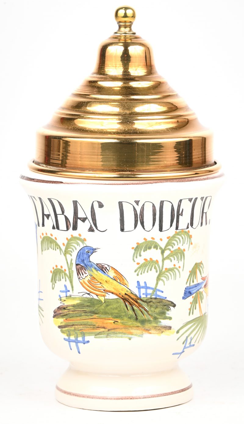 Een porseleinen tabakspot met koperen deksel en vogels in het decor. Onderaan gemerkt “R”.