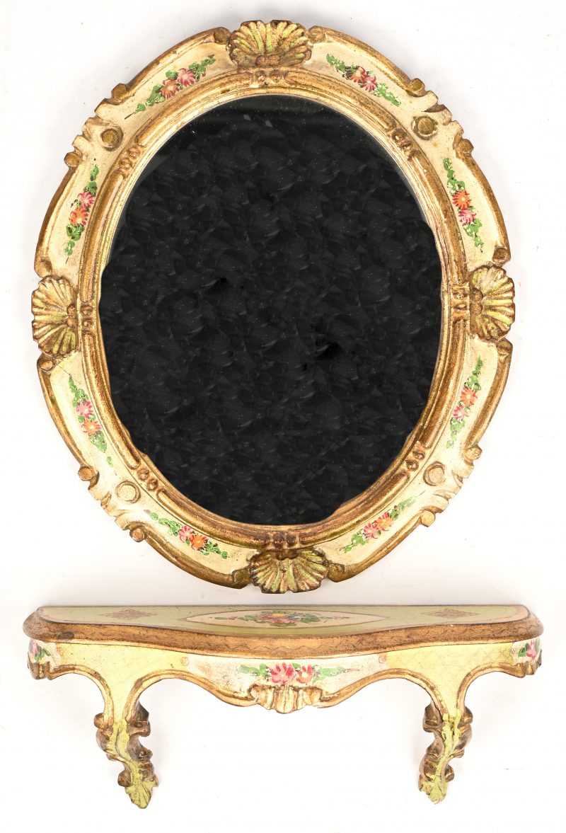 Een ovalen spiegeltje in polychoom gesculpteerd houten kader en wandtablet. Versierd met floraal decor.