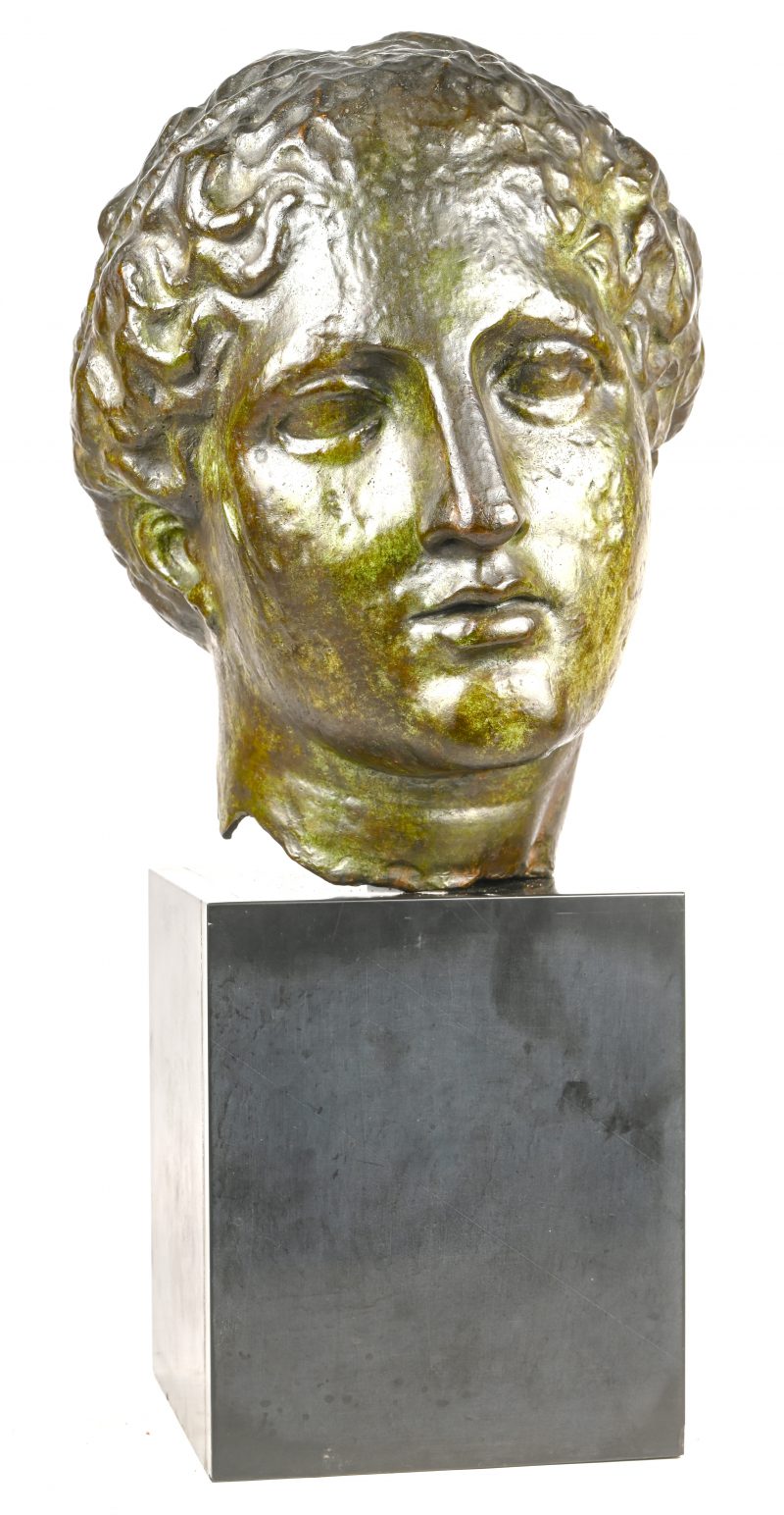 Een brons gesculpteerd hoofd op zwart marmeren sokkel, naar de Griekse oudheid.