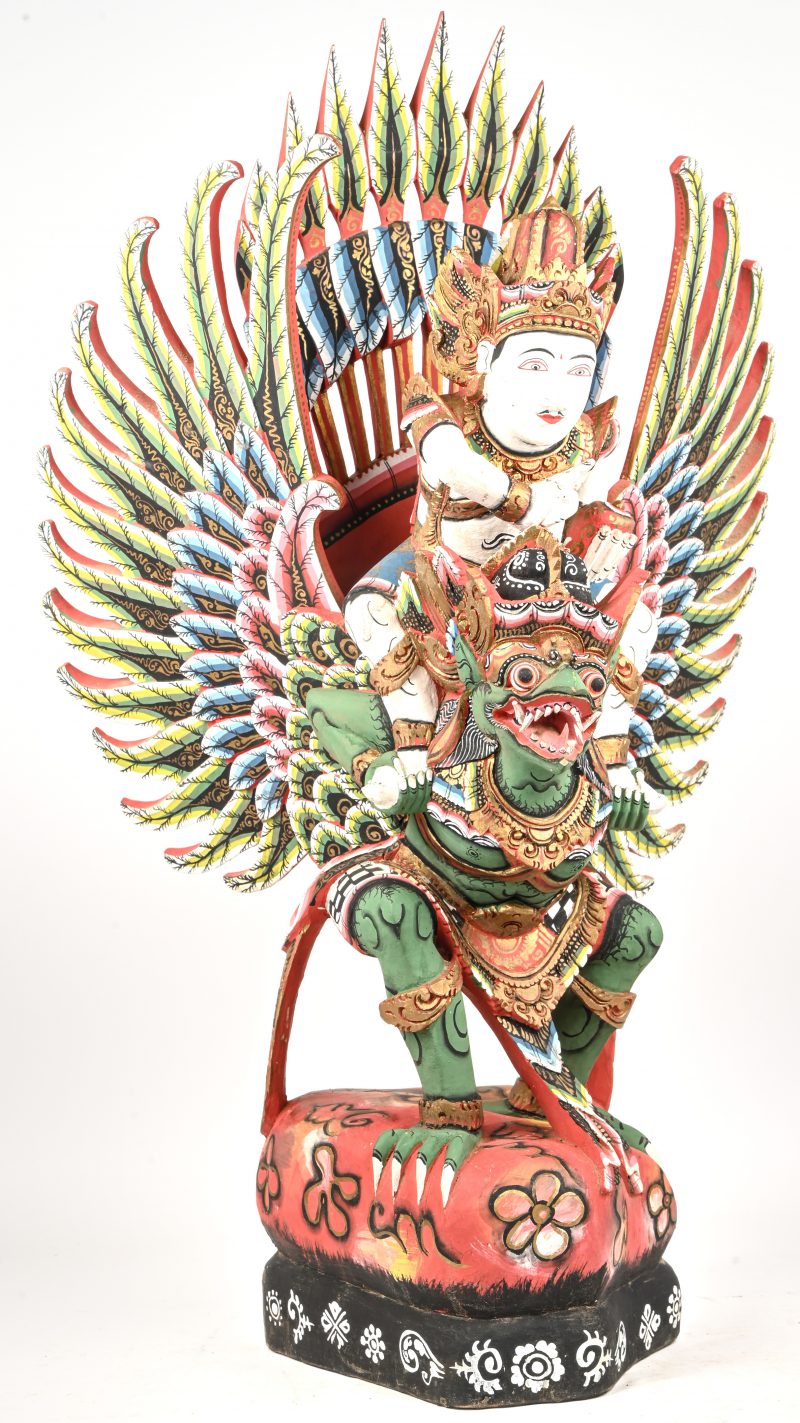 Een Balinees houten gesculpteerd beeld van Vishnu rijdend op Garuda, met meerkleurige beschildering.