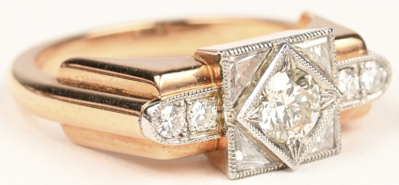 Een 18 karaats wit en roze gouden art deco ring bezet met één centrale briljant van +- 0,72 ct. HP1 en vier diamanten in driehoek geslepen met een gezamenlijk gewicht van +- 0,48 ct. en vier briljanten met een gezamenlijk gewicht van +- 0,15 ct.