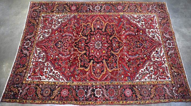 Een meerkleurig handgeknoopt Perzisch tapijt met floraal motief.