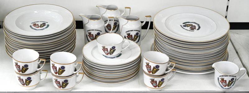 Een porseleinen servies, Antwerpse Federatie Edele Handboog bestaande uit 12 platte borden, 13 diepe borden, 9 dessertborden, 7 tassen, 4 melkkannetjes en een ronde schaal.