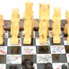 Een opvouwbaar Oosters schaakbord in gesculpteerd hout. De schaakstukken zitten in twee laden in het bord.