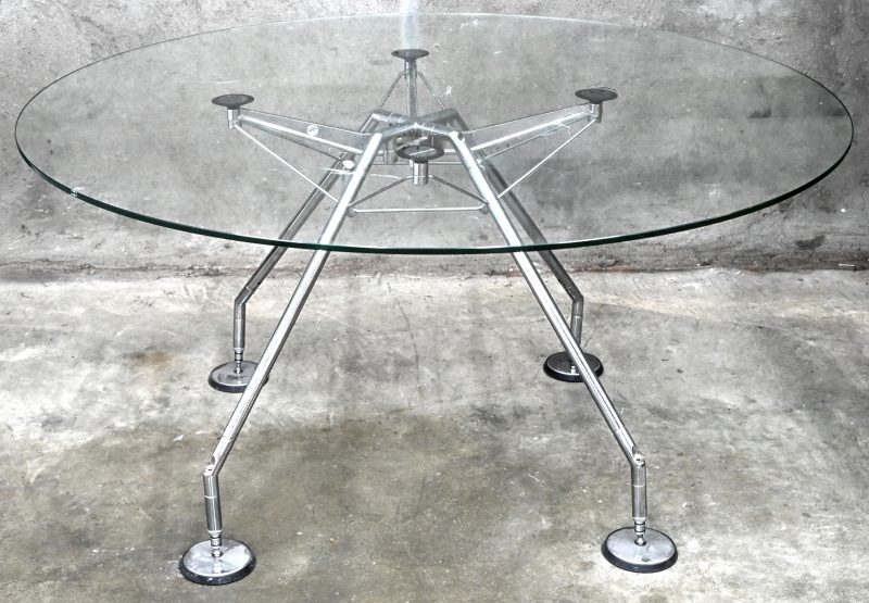 “Nomos”. Een ronde vintage design glazen tafel op gechromeerd staal en metalen poten. Ontwerp door Sir Norman Foster voor Tecno S.p.A, 1987.