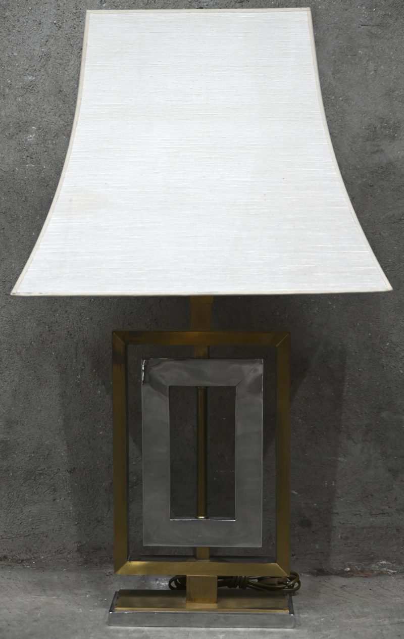 Een midcentury tafellamp met voet in messing en chrome in de stijl van Willy Rizzo met bijhorende ecru stoffen kap.