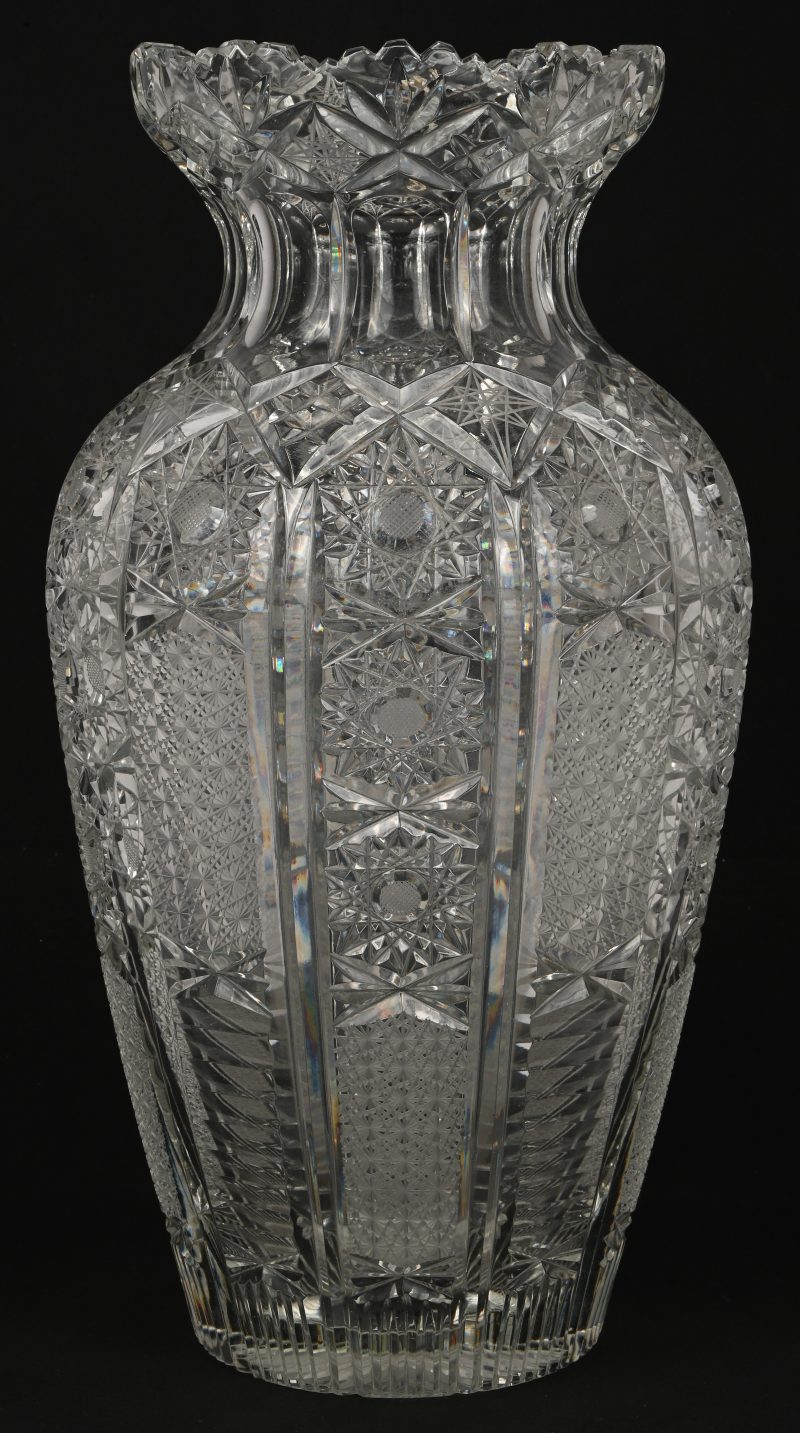 Een grote kristalglazen vaas met gesculpteerd geometrische patronen.