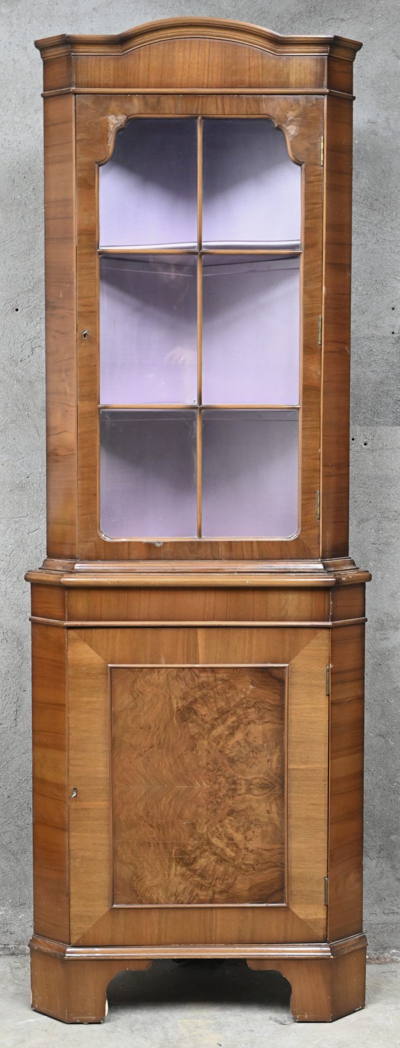 Een houten hoekvitrine met glazen deur, 2 schabben en onderste gedeelte met houten deur.
