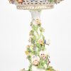 Een porseleinen fruitschaal op voet met bloemenmeisje. De Carl Thieme porseleinfabriek te Dresden. Enkele bloemen missen een blaadje.
