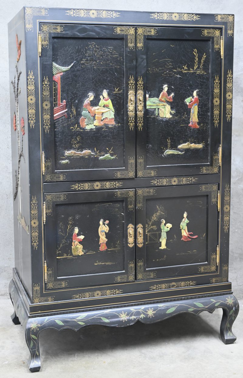 Een zwart gelakte Chinese kast met vier deuren. Figuren in het decor.