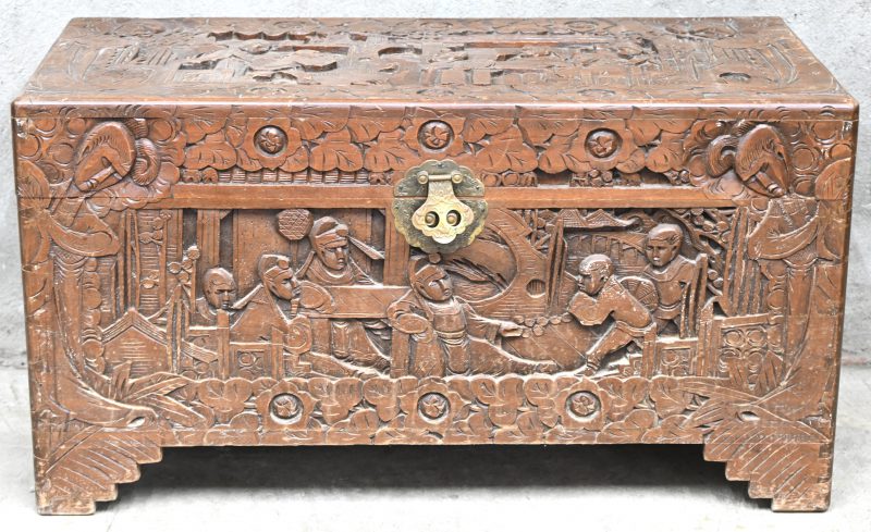 Een Chinese houtgesculpteerde koffer met figuren in het decor.