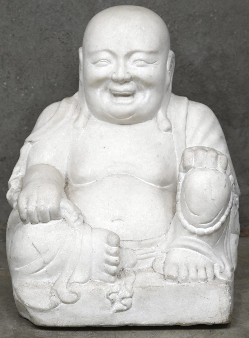 Een Chinese lachende Buddha in steen gehouwen, in zittende positie.
