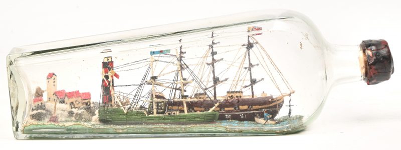 “Zeemanskunst”, een diorama in een fles voorstellend een kustdorpje met vuurtoren, twee driemasters en een roeibootje.