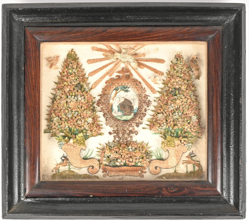 Een religieus kadertje met een geschilderd miniatuurtje omringd door homen en dieren. 19e eeuws huisvlijt.