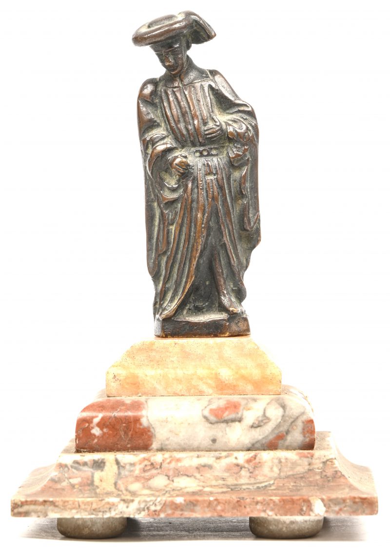 Een bronzen beeldje van een edelman op een marmeren voet.