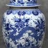 Een grote Chinees porseleinen dekselvaas met uitgebreid blauw en wit decor van een draak, pauw en bloemen.