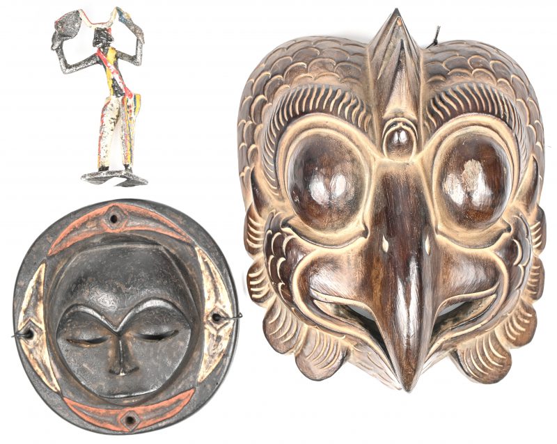 Een gevarieerd lot etnisch materiaal bestaande uit een houten kippen masker, een Afrikaand masker in hout en een polychroom Afrikaans beeldje in aluminium.