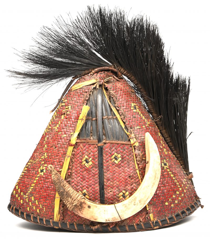 Een ceremoniële hoed van de Naga, vervaardigd uit gewoven bamboe, versierd met zwijn slagtanden. Nagaland, Indië, vroeg 20e eeuw.