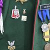 Een militair parade-kostuum met bijhorende kepi en een badge met opschrift Reigersvliet.