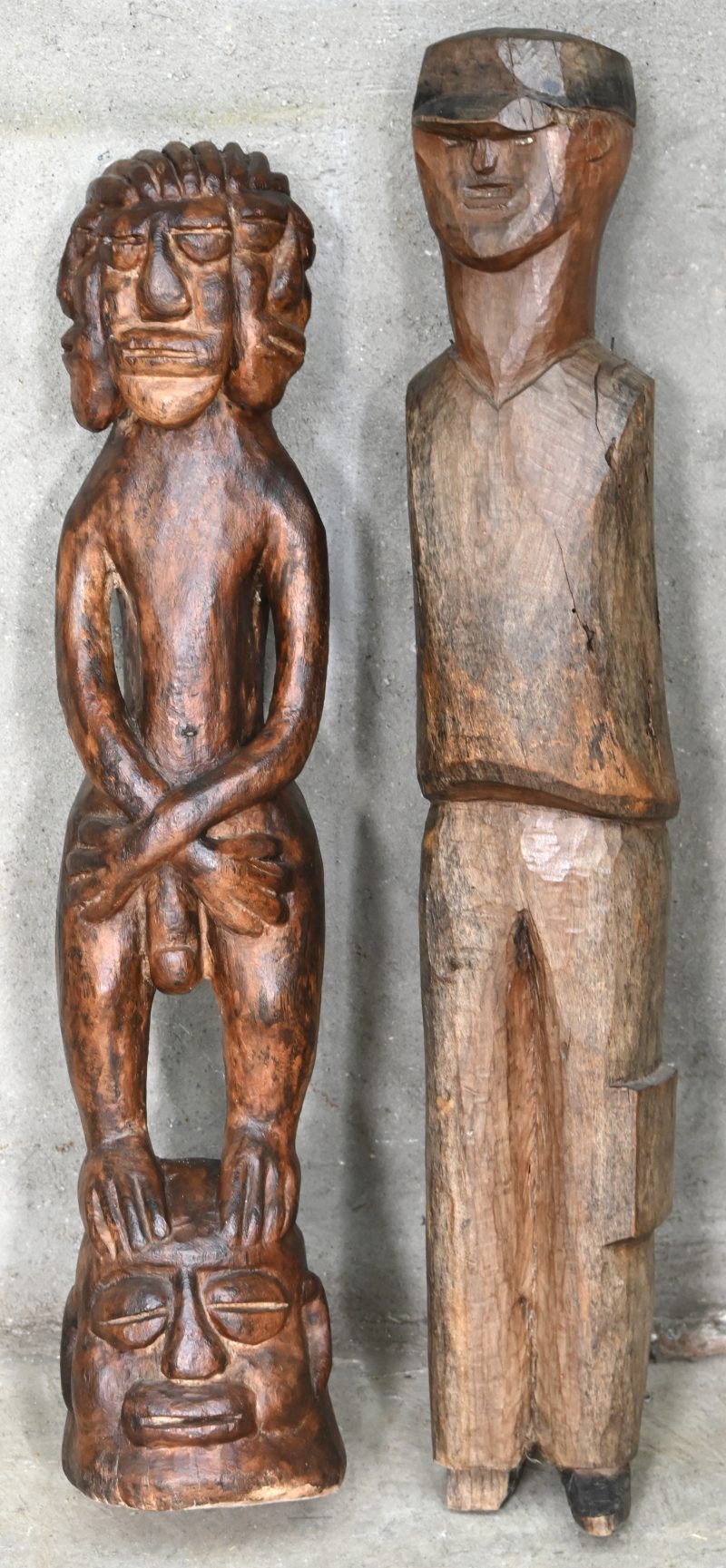 ‘Man met drie gezichten’ en ‘Europeaan met kepie’. Twee Afrikaanse houtsculpturen.