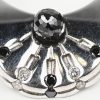 Een 18 kt witgouden design ring bezet met zwarte briljanten met een gezamenlijk gewicht van +- 0,32 ct. en witte stenen van 0,06 ct.
