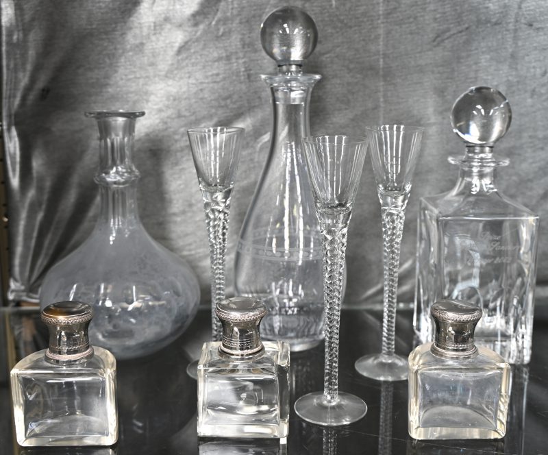 Negen stuks divers glaswerk met drie parfumflesjes waarvan één stopje stuk, drie karaffen waarvan één stop ontbreekt en drie lange likeurglaasjes.