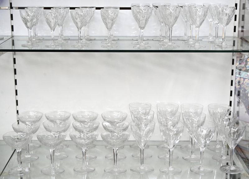 Een glasservies van kristal waaronder 12 champagne koepjes, 12 witte wijnglazen, 12 rode wijnglazen en 12 waterglazen.