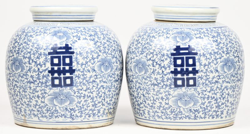 Een paar gemberpotten van Chinees porselein met een blauw op wit decor van gelukstekens op florale achtergrond.