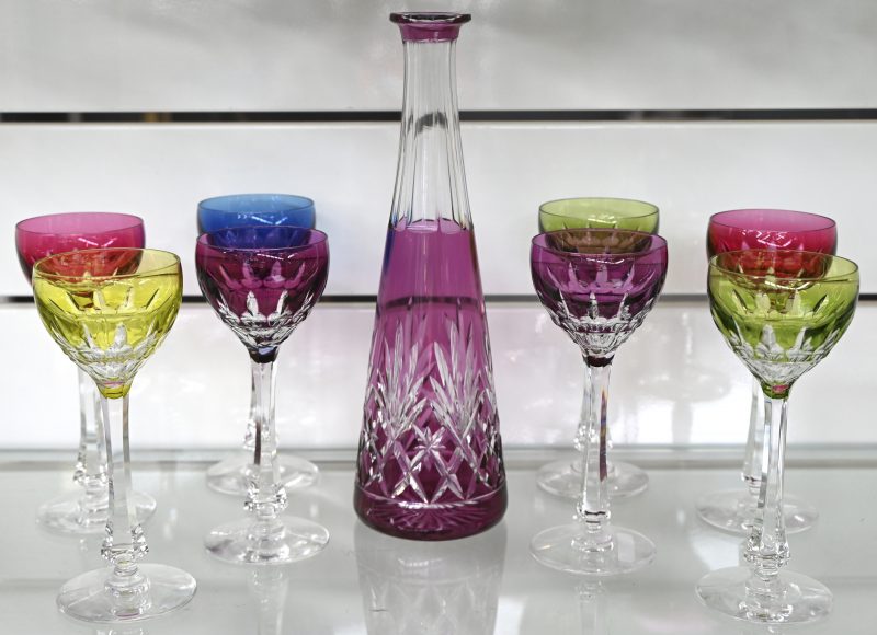 Een lot van 8 gekleurd kristallen glazen en karaf met geslepen geometrisch decor. Dop karaf manco en 1 glas met barst.