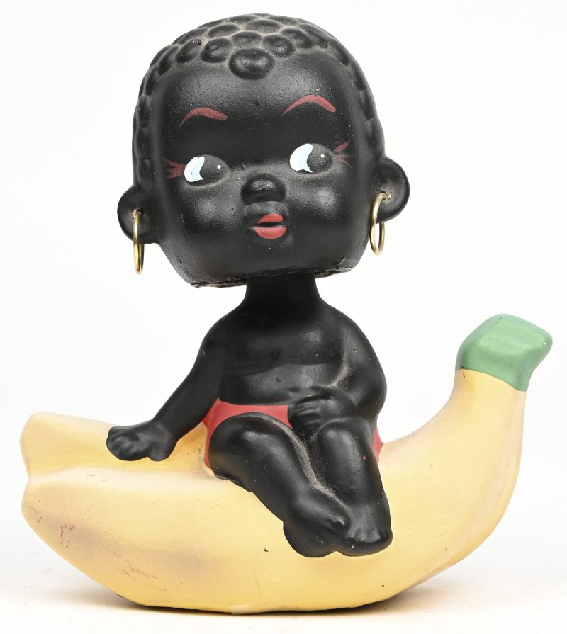 Een vintage spaarpotje voorstellend een Afrikaans kindje op een banaan.