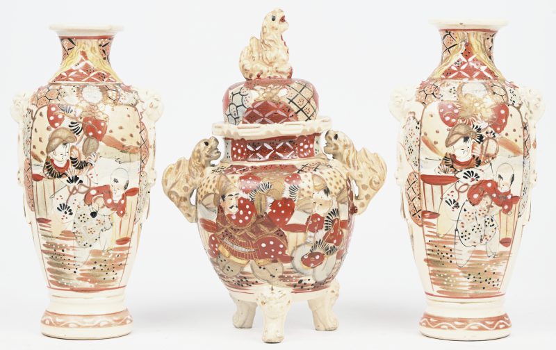 Een lot van Satsuma aardewerk bestaande uit een dekselvaasje en een set vaasjes waarvan één met herstelling.