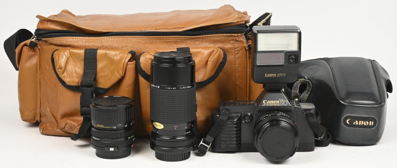 Een analoog fototoestel, Canon T70 met 3 lenzen, Canon FD 50mm 1:1.4, Canon FD 35-70mm 1:3.5-4.5 en een Sigma zoom, 75-210mm 1:3.5-4.5. Met draagtas, boekjes en andere toebehoren.