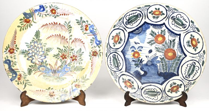 Twee aardewerken borden met bloemendecor. XVIIIde eeuw. Randschade en oude restauratie.
