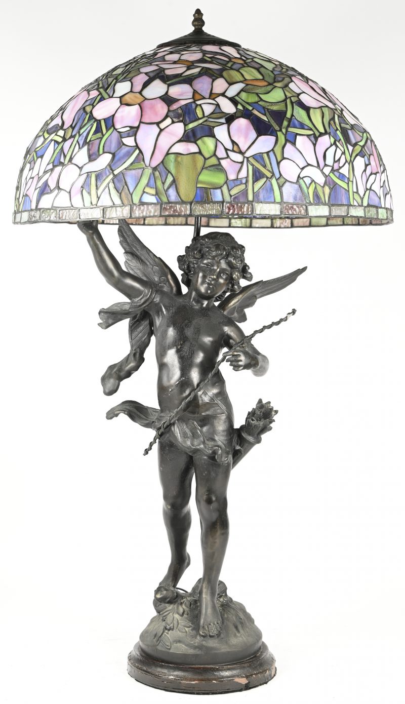 Een tafellamp voorstellend een beeld in zamak van een engel, naar Auguste Moreau, met een lampenkap in Tiffany-stijl.