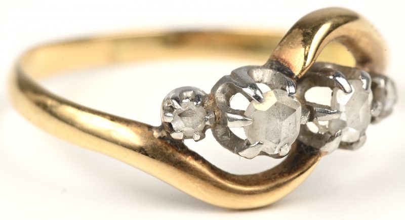 Een 18 kt wit en geelgouden ring bezet met diamanten oude slijp met een gezamenlijk gewicht van +- 0,12 ct.