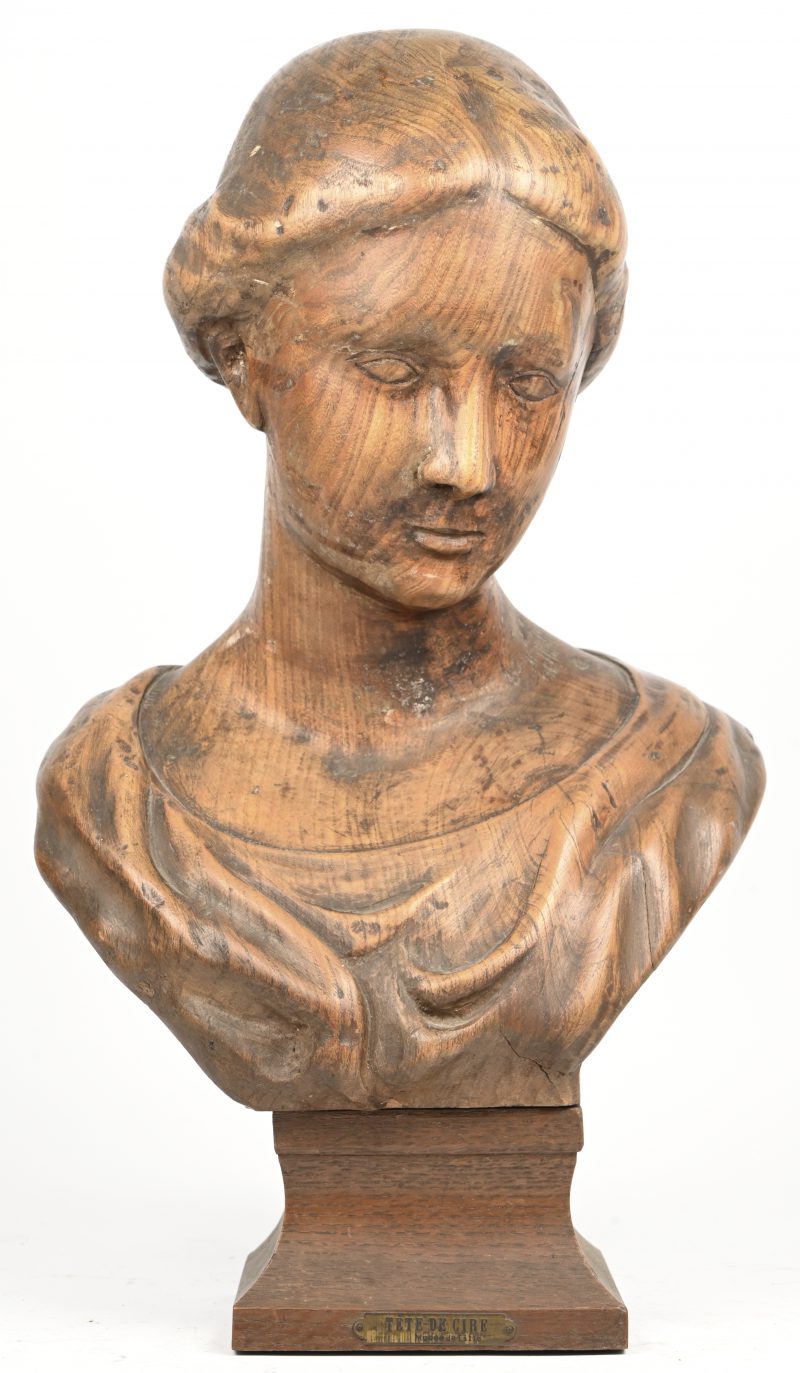 “Damesbuste”. Een massief houten gesculpteerde busten van een jongedame op houten sokkel. Draagt een plaatje met opschrift ‘Tète de Cire - Musée de Lille’.