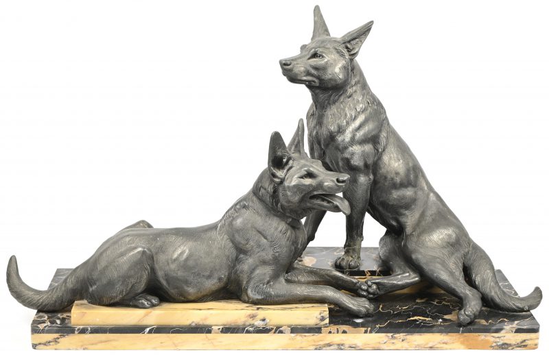 Een art-deco beeldengroep van 2 honden in zamak op een voet in 2 soorten marmer. Eén poot van een hond is gebroken.