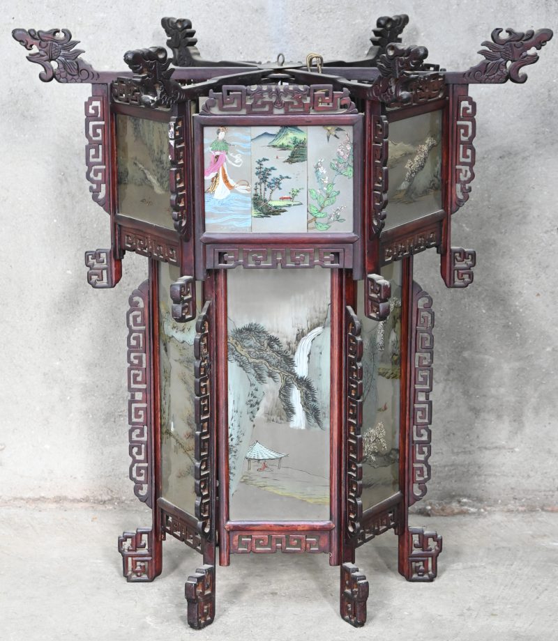 Een grote zeshoekige Chinese lantaarn in hout en beschilderd glas met landschappen in het decor. Eén van de glazen ontbreekt/is vervangen door 3 kleine beschilderde glazen.
