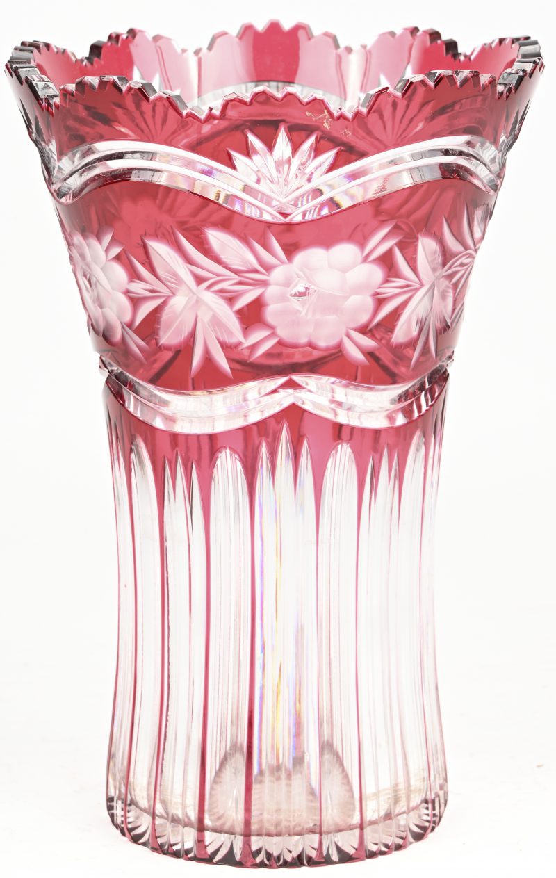Een boheems kristallen vaas, rood in de massa gekleurd en een geslepen bloemmotief.