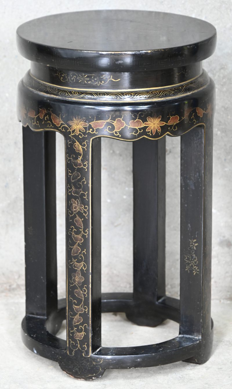 Een beschilderd houten Chinees krukje, zwart met goudkleurige florale motieven.