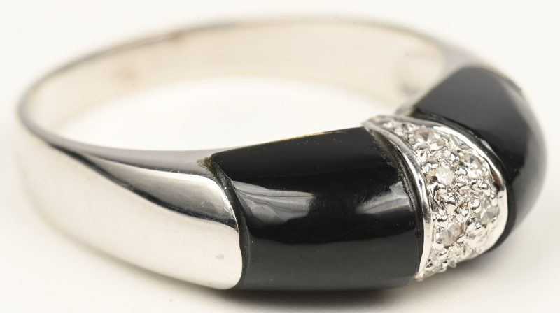 Een 18 kt witgouden ring bezet briljantjes met een gezamenlijk gewicht van +- 0,08 ct. en onyx.