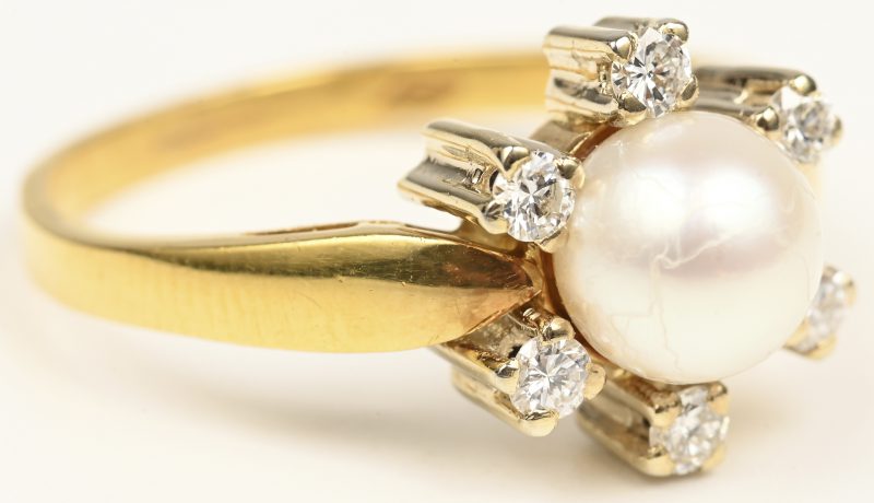 Een 18 kt geelgouden ring bezet met briljanten met een gezamenlijk gewicht van +- 0,24 ct. en een parel.