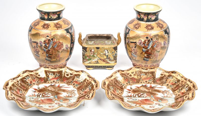 Een lot van vijf stuks Japans Satsuma porselein bestaande uit 2 vazen, 2 borden en een dekselpotje waarvan het deksel ontbreekt.